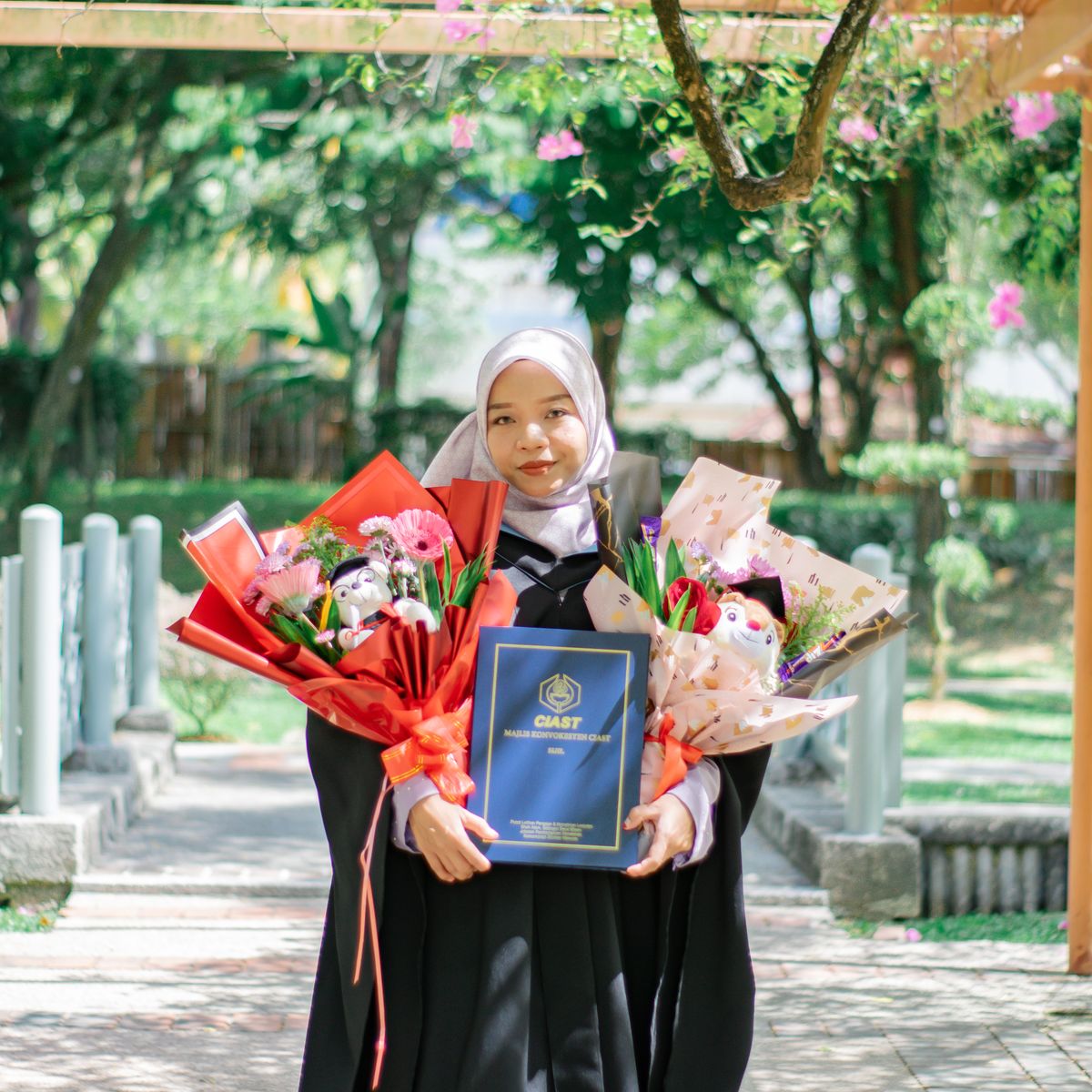 Graduate student celebrating in a park in Malaysia