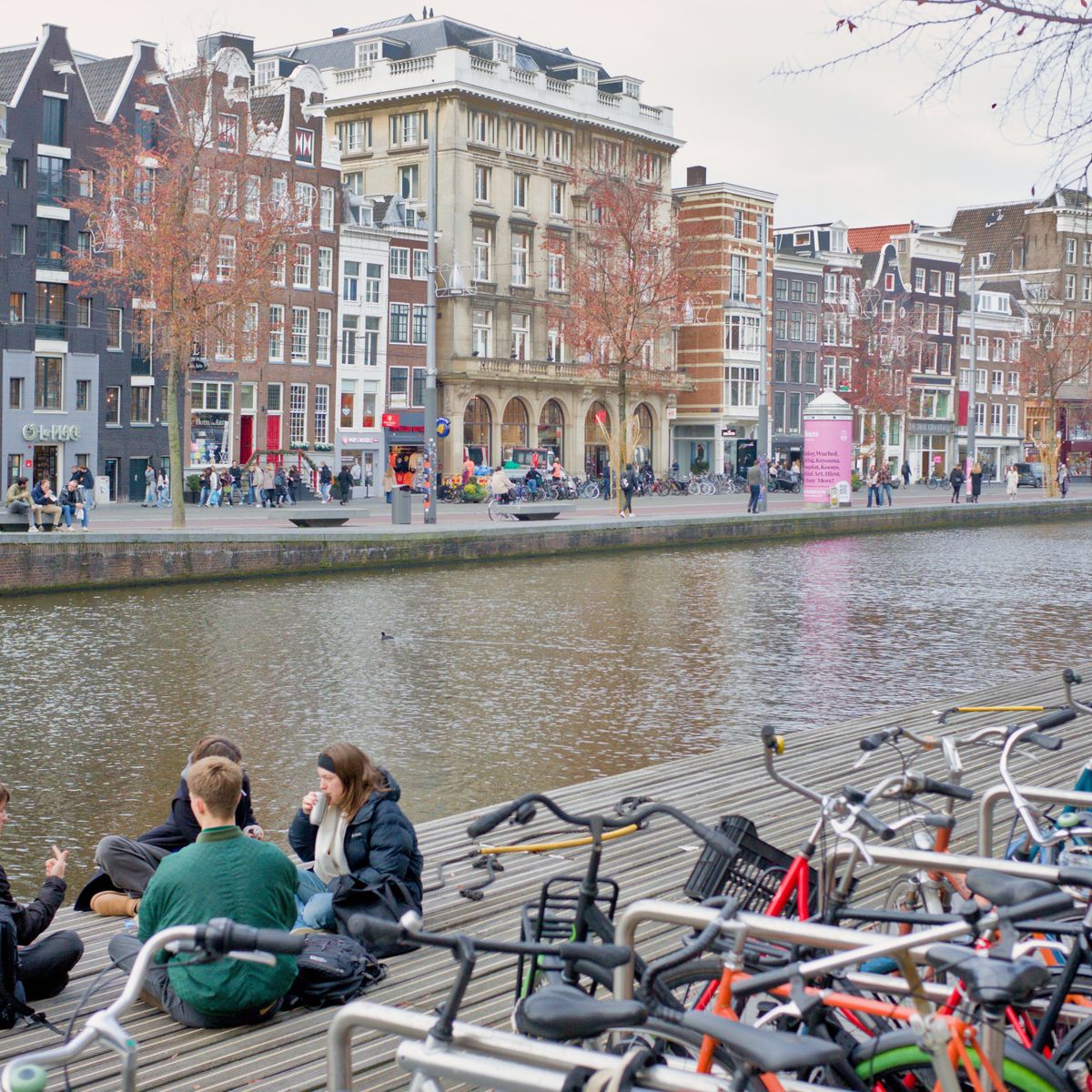 Young adults relaxing by an Amsterdam canal